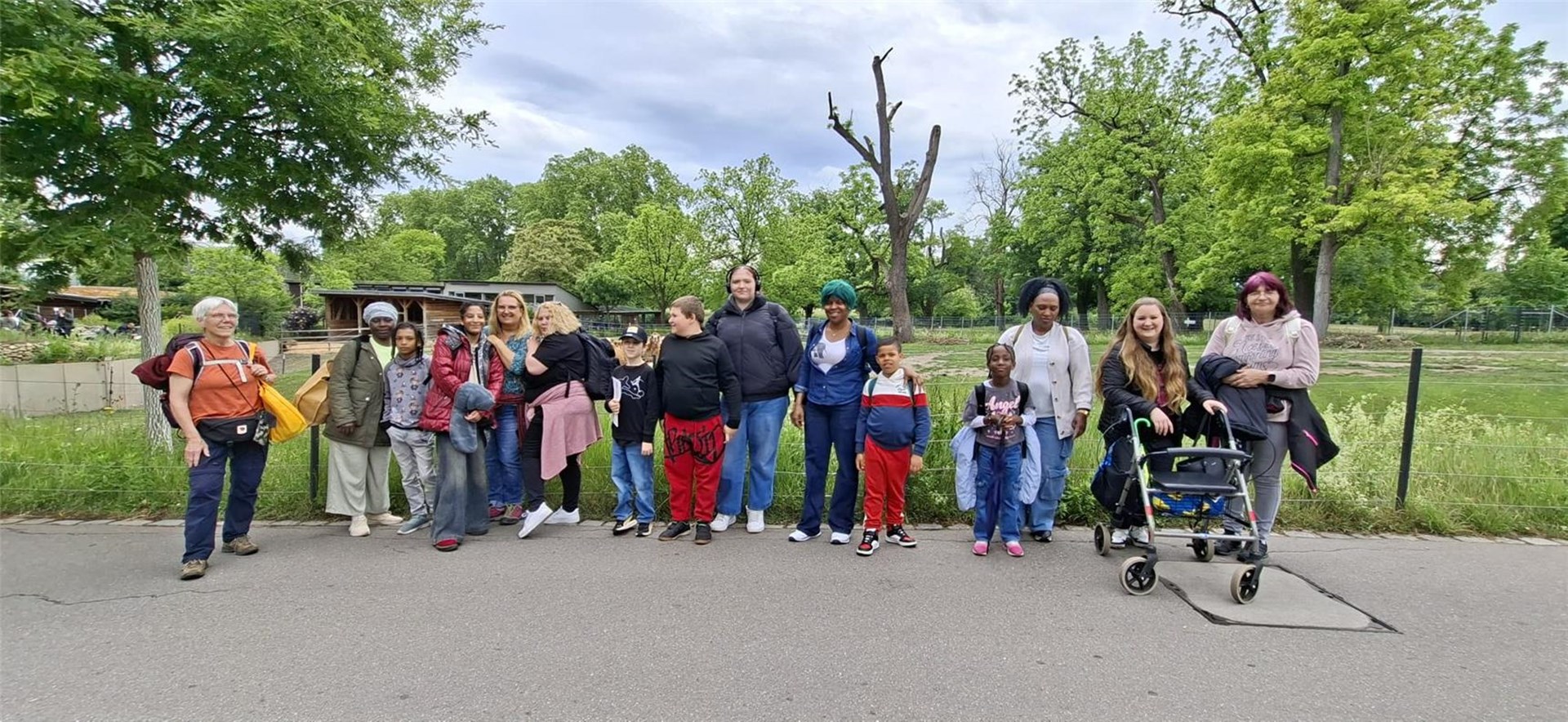 Mehrere Menschen stehen gemeinsam und lächeln in die Kamera. Es sind einige Kinder dabei. Eine Frau hat einen Rollator. Ganz links steht Lydia Fried, Sozialarbeiterin des Caritasverbandes.