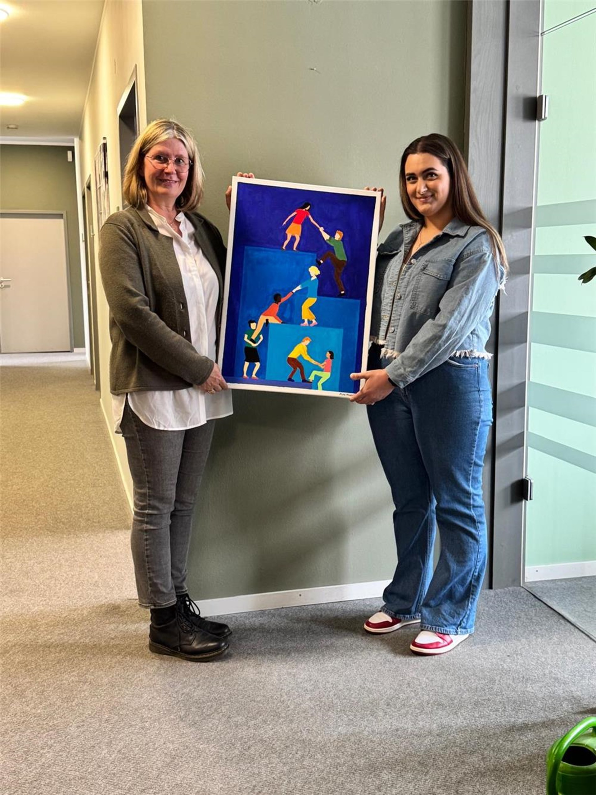 Petra Scherchel, Leiterin des Mogrationsdienstes hält, gemeinsam mit Alina Moscalenco das gespendete Bild