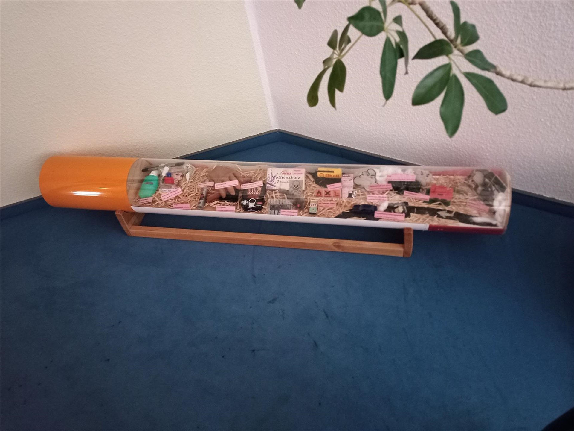 Eine Modell-Zigarette aus Kunststoff ist gefüllt mit allen möglichen Schadstoffen, die in einer Zigarette enthalten sind.